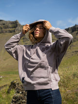 ION Hoody No Bad Days 2026 in Hellgrau, Kapuzenpullover mit Reißverschluss, getragen mit Kappe in grüner Berglandschaft