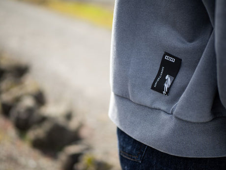 ION Sweater Mood 2026 grau, Strickpullover mit schwarzem Label-Patch an der Seite, Detailansicht