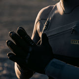ION Neo Gloves 4/2 2026 schwarz, Neoprenhandschuhe an Sportler getragen, Detailansicht Hand und Anzug