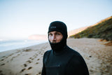 ION Neo Top Hooded Vest 2/1 2026 schwarze Neopren-Weste mit Kapuze, Frontalansicht am Strand getragen