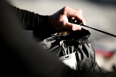 ION Kite Crushbag 2026 schwarz, Transporttasche mit Zugband, in Hand gehalten am Strand