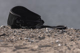 ION Core Long Sicherheitsleine 2026 schwarze Kiteboard-Leine mit Metallkarabiner auf Sand