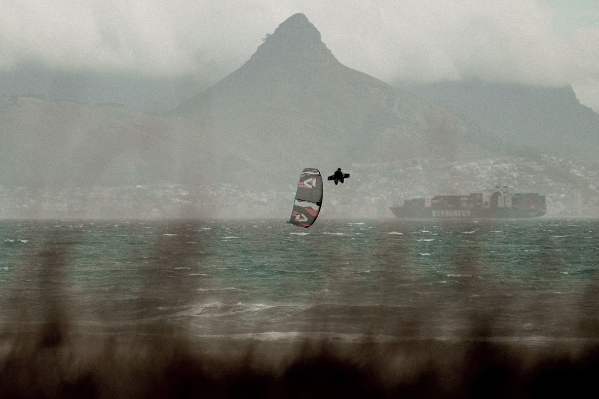 ION Core Long Sicherheitsleine 2026 in Verwendung beim Kiteboarding auf dem Wasser mit Bergkulisse
