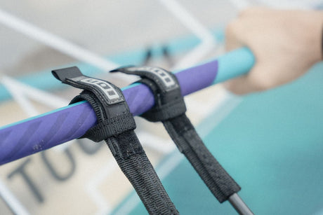 ION Windsurf Harness Line Fix Pro 2026 mit schwarzen Befestigungsgurten auf violettem Boom, Detailansicht