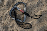 ION Uphaul Line TEC 2026 Trapezleine in Schwarz und Grau mit gepolsterten Griffen, Draufsicht am Strand