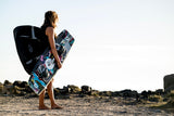ION Suspect Duffel Bag 2024 schwarz, Kitesportler trägt Tasche, Strandszene