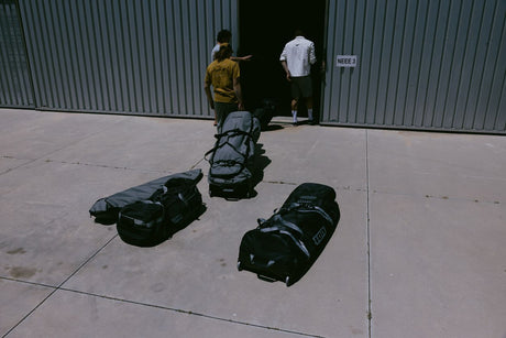 ION Gearbag Tec Golf 2026 schwarze Ausrüstungstasche mit Rollen und Griffen, Frontalansicht auf Betonboden