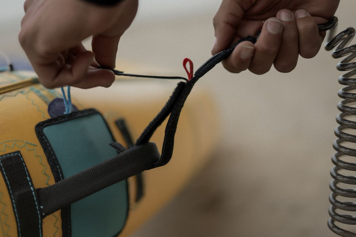 ION Wing Leash Core Coiled Wrist schwarz mit Befestigungspunkt, Detailansicht der Handhabung