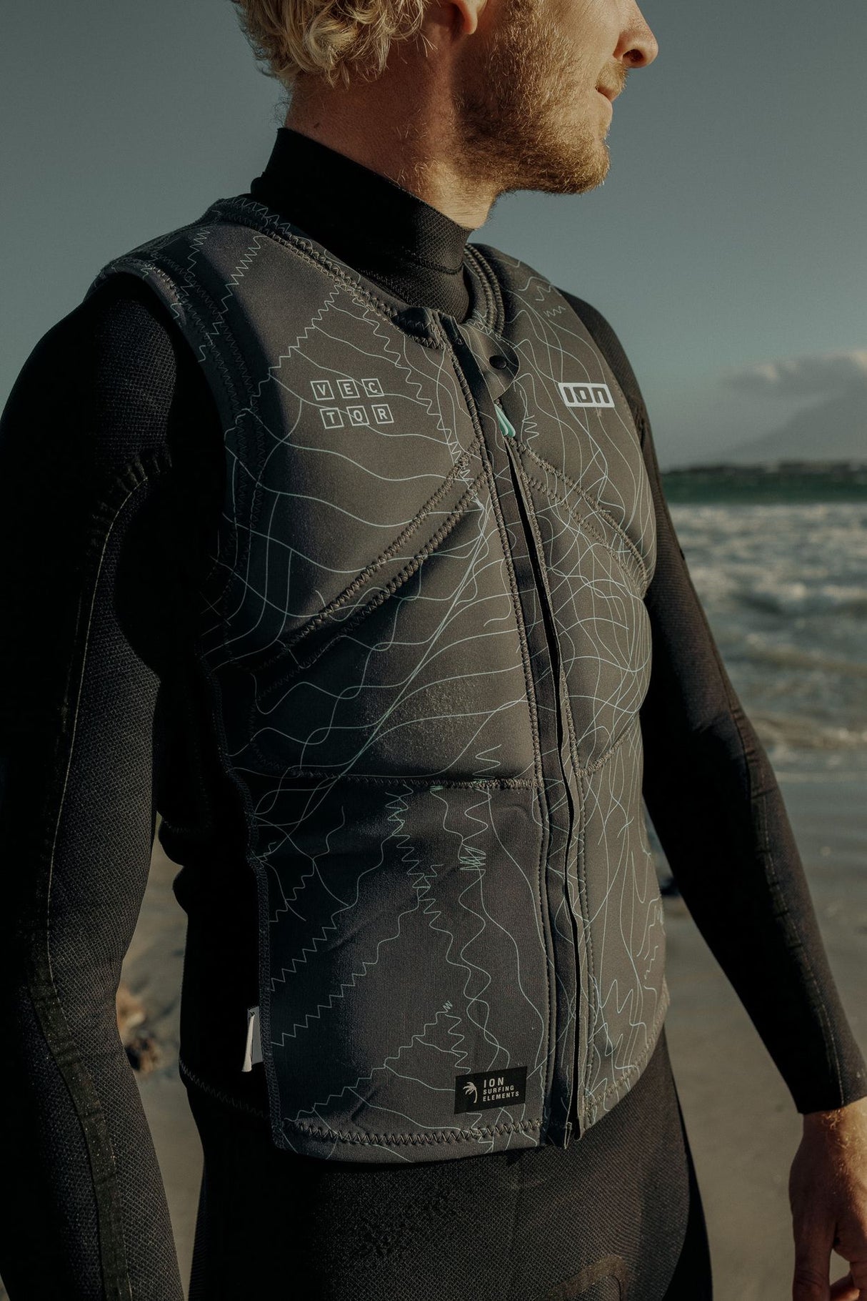 ION Vector Vest Core Front Zip Herren 2024 schwarz, Neopren-Weste mit Reißverschluss, Seitenansicht am Strand