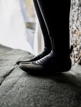 ION Plasma Boots 3/2 Internal Split schwarz, getragen auf Stein, Detailansicht Sohle und Ferse