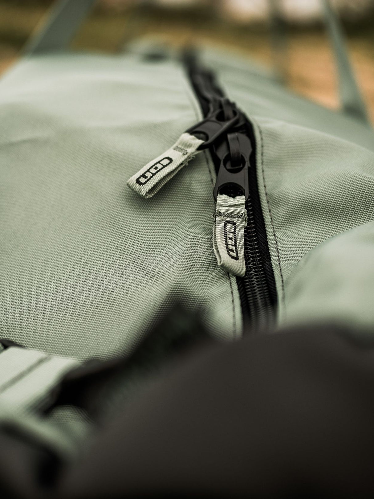 ION Wing Quiverbag Core 2026 Detailansicht Reißverschluss auf graugrünem Neopren-Material mit schwarzem Zipper