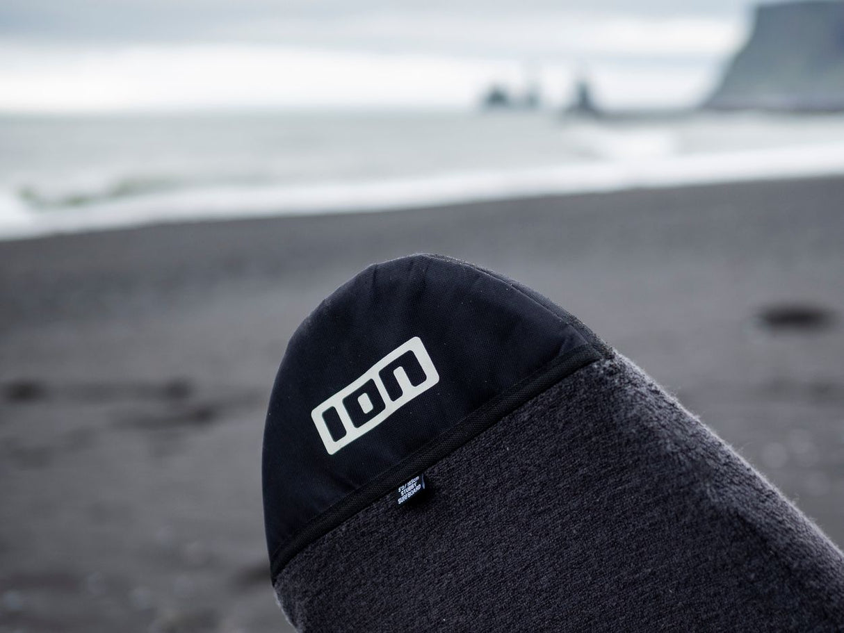 ION Surf Sock Stubby 2024 SS in Dunkelblau und Grau, Neopren-Socke am Strand, Nahaufnahme mit ION-Logo