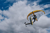 ION Mission 2026 Kiteboard in Gelb-Schwarz, Flugansicht mit Kite am bewölkten Himmel