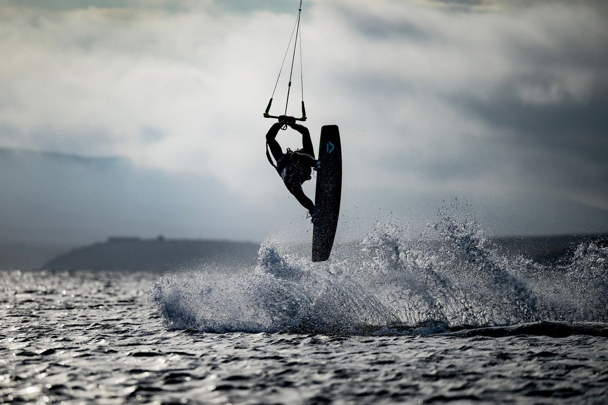 ION Handle Pass Leash Comp 2026 Kitesurf-Trapezgurt in Schwarz, Athlet in Aktion auf dem Wasser