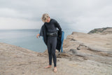 ION Neo Cruise Jacket Herren 2024 schwarz, Neopren, Mann trägt Jacke am Strand mit Kiteboard