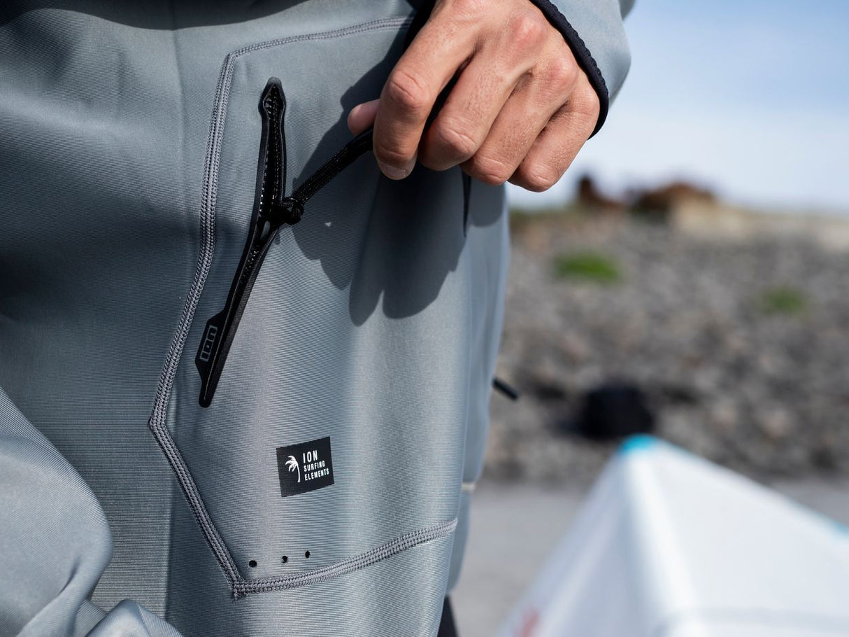 ION Neo Hoody Lite Herren 2025 in Grau, Detailansicht mit Reißverschlusstasche und Logopatch