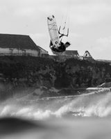 ION Ivy Weste Front Zip 2026 in Schwarz, Kitesurfer in Aktion über Wellen, Frontalansicht, Funktionsweste