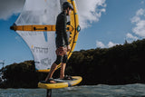 ION Wing Knee Sleeve 2026 schwarz, Athlet beim Kiteboarden mit Knieprotektor in Aktion auf dem Wasser