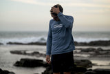 ION Wetshirt LS Herren 2025 in Blau mit Langarm, getragen am Strand mit Meereskulisse