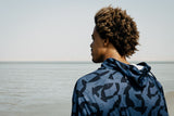 ION Wetshirt Hood Langarm Herren 2026 in Blau mit geometrischem Muster, Rückansicht am Meer