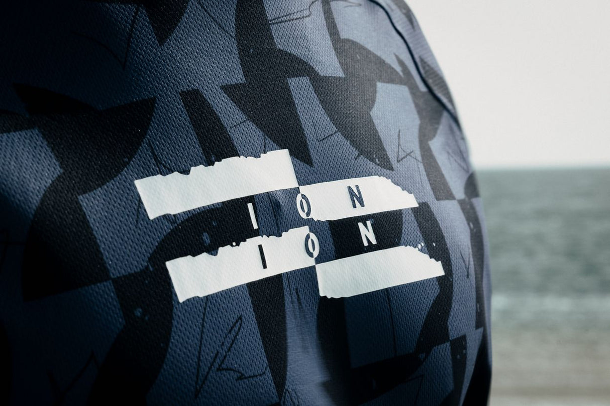 ION Wetshirt Hood Langarm Herren 2026 navy Karo-Muster mit ION-Logo, Frontalansicht am Strand