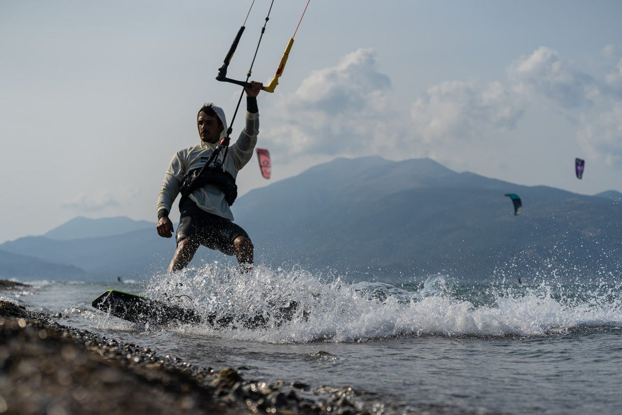ION Wetshirt Hood Langarm Herren 2026 grau, Wassersportler beim Kitesurfen im Meer, Frontalansicht