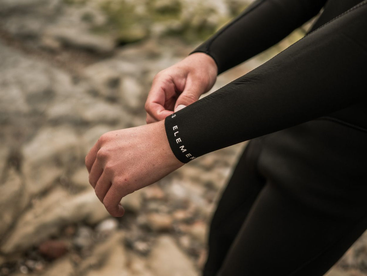ION Element 4/3 Back Zip Neoprenanzug in Schwarz, Detailaufnahme des Ärmels mit Reißverschluss an der Person getragen
