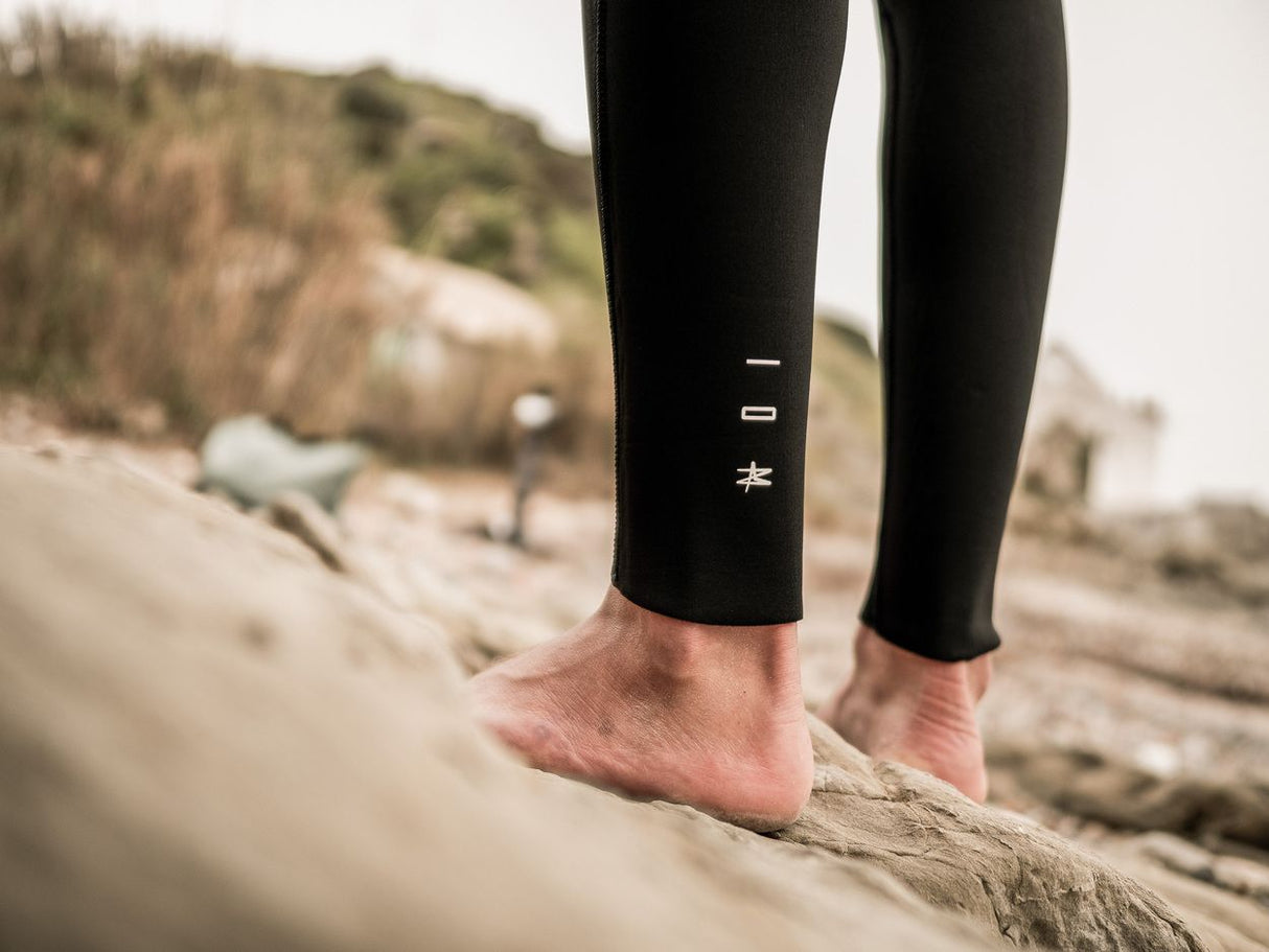 ION Element 4/3 Back Zip 2026 Neoprenanzug in Schwarz, getragen am Strand, Detailansicht der Beine