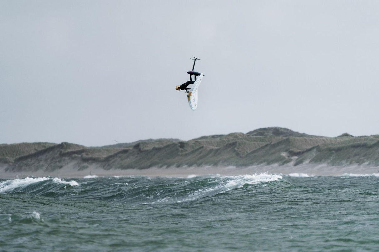 ION Element 4/3 Back Zip 2026 Neoprenanzug in Schwarz-Weiß, Kitesurfer in Aktion über Welle