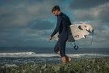 ION Element 4/3 Overknee LS Back Zip Neoprenanzug in Dunkelblau, Surfer trägt Anzug mit Surfbrett am Strand