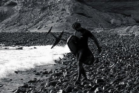 ION Static 2/2 Shorty Back Zip 2026 schwarzer Neoprenanzug mit Rückenreißverschluss, Surfer trägt Anzug am Strand