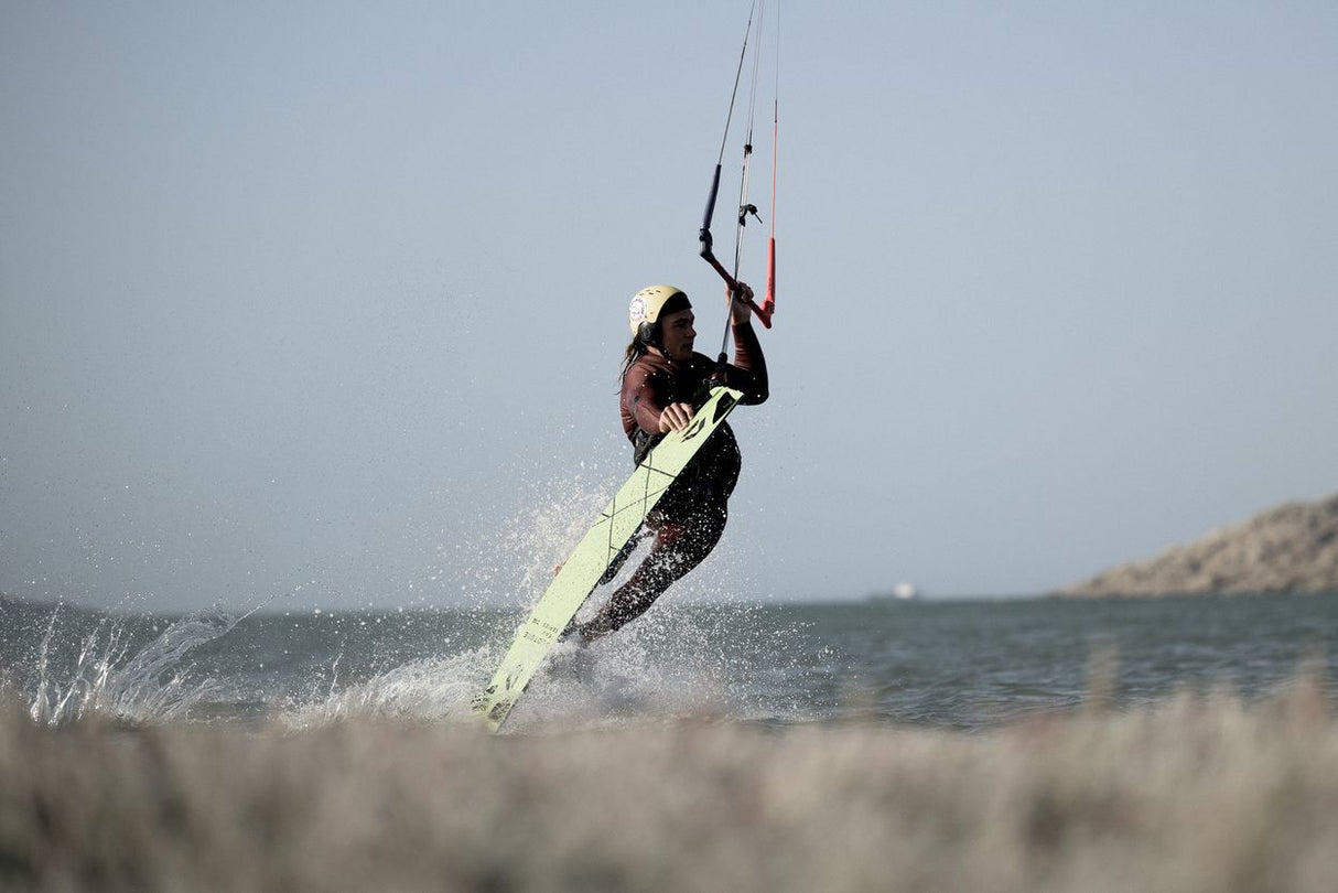 ION Rival Kite Trapez Herren 2026 in Schwarz-Gelb, Kitesurfer in Aktion auf dem Wasser