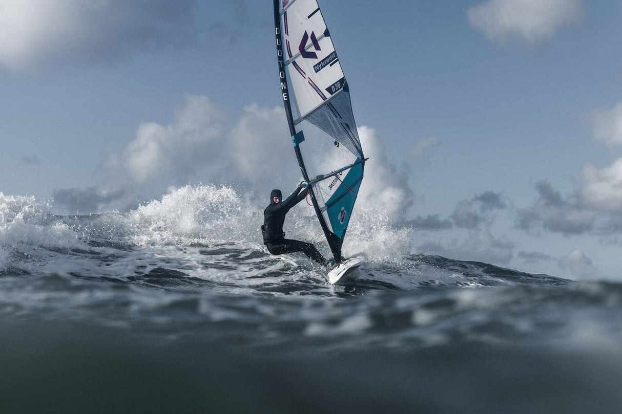 ION Axxis Windsurf Trapez Herren in Schwarz-Weiß, am Windsurfer im Wasser bei Wellengang getragen
