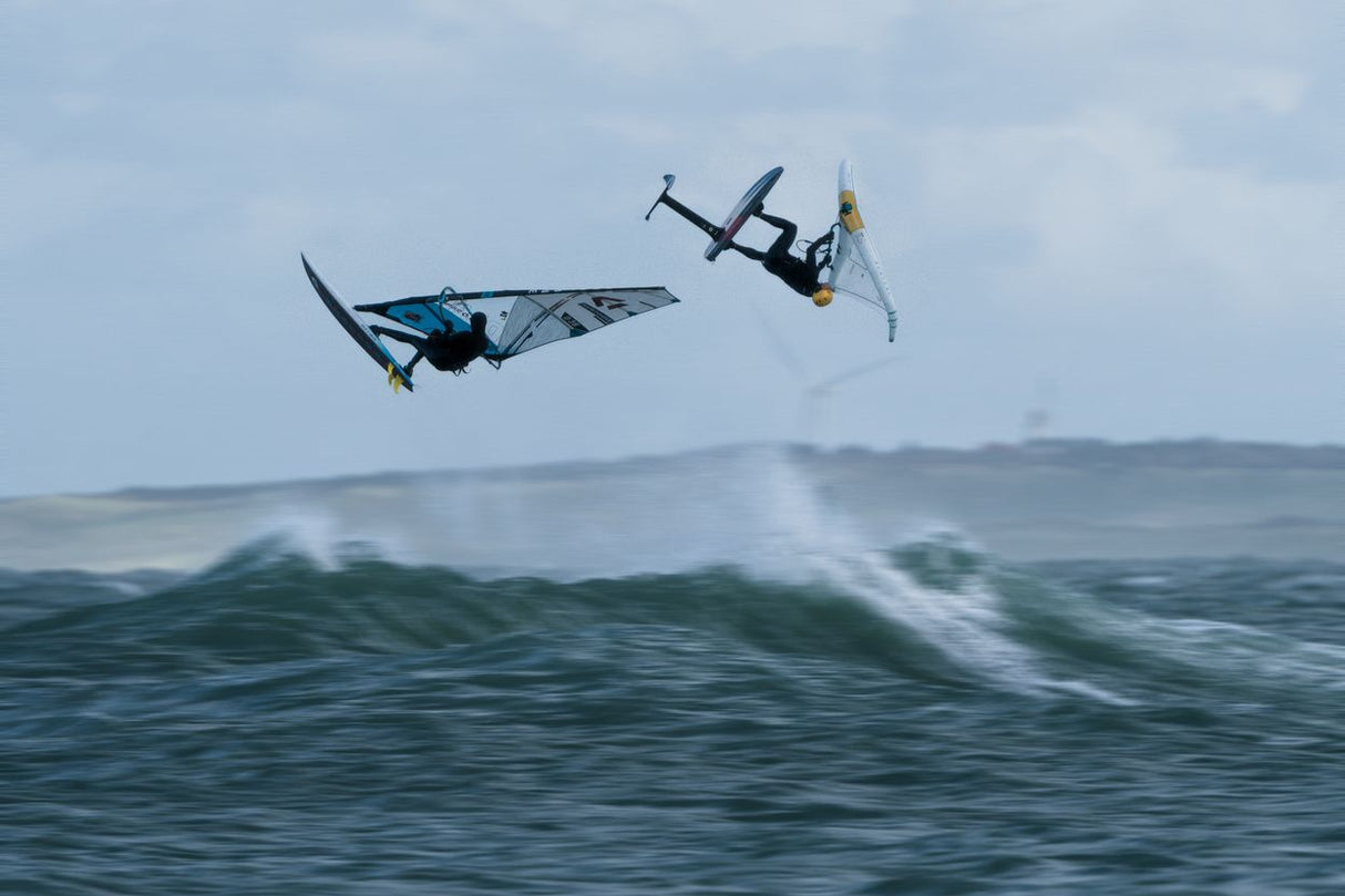ION Axxis Windsurf Trapez Herren 2026 in Blau, Athlet in Aktion über Wellen, Seitenansicht