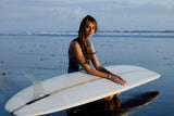 ION Amaze V-Back 1.5 Damen Neoprenanzug in Schwarz, Frontansicht mit Surfboard am Strand