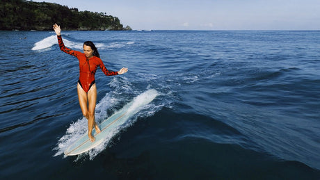ION Amaze Hot Shorty 1.5 LS Neoprenanzug in Rot, Frau beim Surfen im Meer von vorne