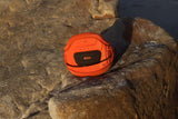 ION Muse Kite Trapez 2026 orange mit schwarzem Pad auf Felsen, Frontansicht