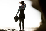 ION Muse Kite Trapez 2026, schwarzes Neopren-Trapez mit farbigen Details, von hinten getragen am Strand