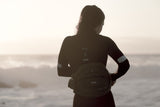ION Muse Kite Trapez 2026 schwarzes Trapez, getragen von Person am Strand mit Meereshintergrund, Frontalansicht