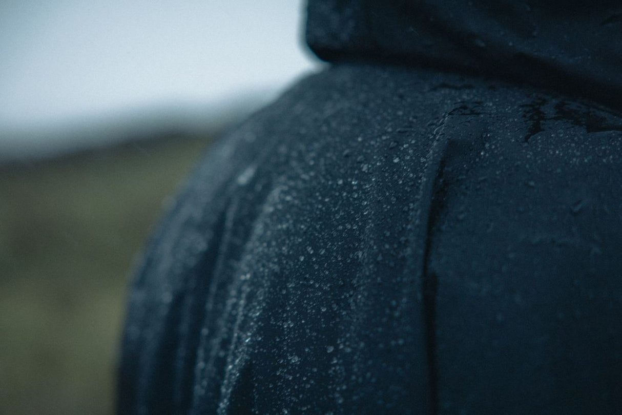 ION Storm Coat unisex 2026 in Dunkelblau mit Wassertropfen, Detailansicht Schulterbereich