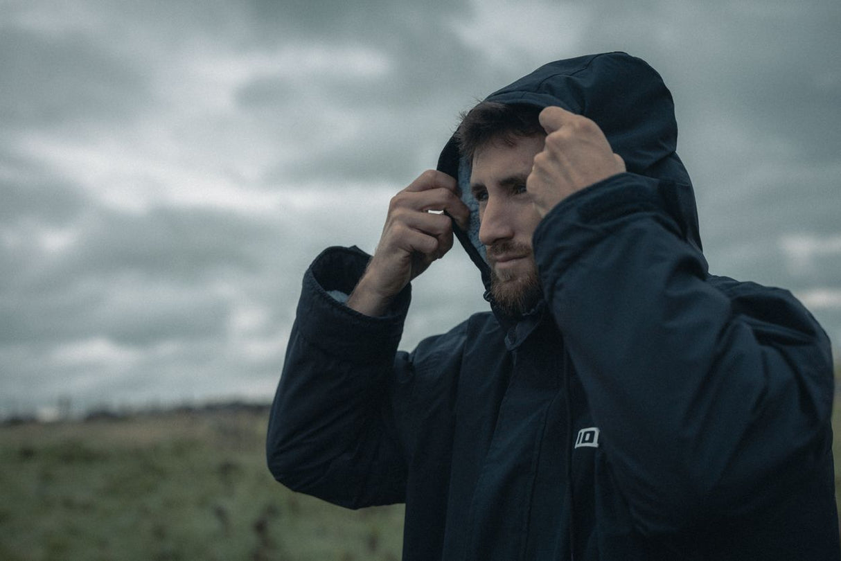 ION Storm Coat unisex 2026 dunkelblau, Funktionsjacke mit Kapuze, getragen von Person in Außenszenerie