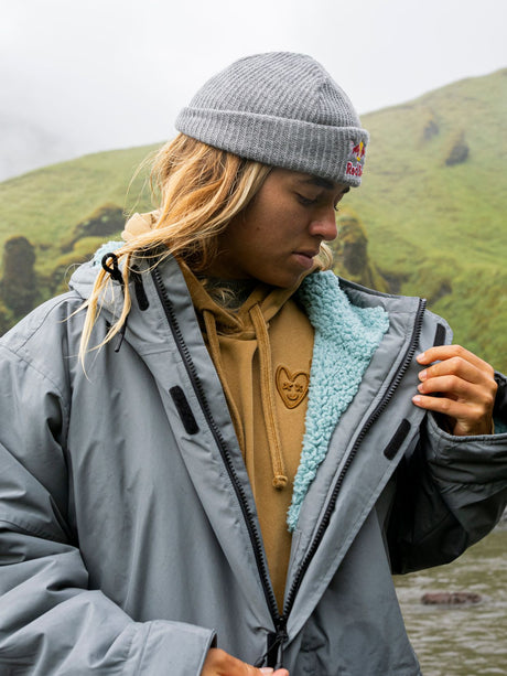 ION Storm Coat Unisex 2026 grau mit Fleece-Futter, modellansicht von vorne in bergiger Landschaft