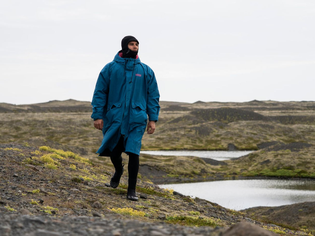 ION Storm Coat unisex 2026 in Blau, Funktionsjacke aus Kunstfaser, wasserdicht, modelliert an Person in Landschaft