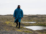 ION Storm Coat unisex 2026 in Blau, Funktionsjacke aus Kunstfaser, wasserdicht, modelliert an Person in Landschaft