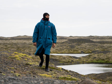 ION Storm Coat unisex 2026 in Blau, Funktionsjacke aus Kunstfaser, wasserdicht, modelliert an Person in Landschaft