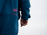 ION Storm Coat unisex 2026 in Dunkelblau mit pinkem Logo, Seitenansicht, Detailaufnahme Ärmel und Schulter