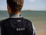 ION Rush Wing Vest 2026 in Schwarz-Weiß, Rückansicht am Strand getragen, Funktionsweste mit ION-Logo