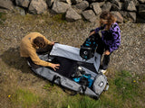 ION Kite Gearbag Core 2026 grau, geöffnet mit Kiteanlagen, Draufsicht, zwei Personen beim Packen