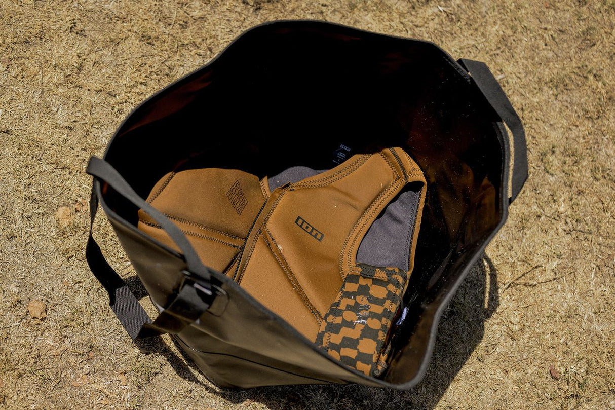 ION Changing Bucket 2026 Wetsuit-Tasche khaki, geöffnet mit Innenfächern, Draufsicht auf Sand
