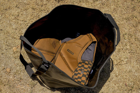 ION Changing Bucket 2026 Wetsuit-Tasche khaki, geöffnet mit Innenfächern, Draufsicht auf Sand